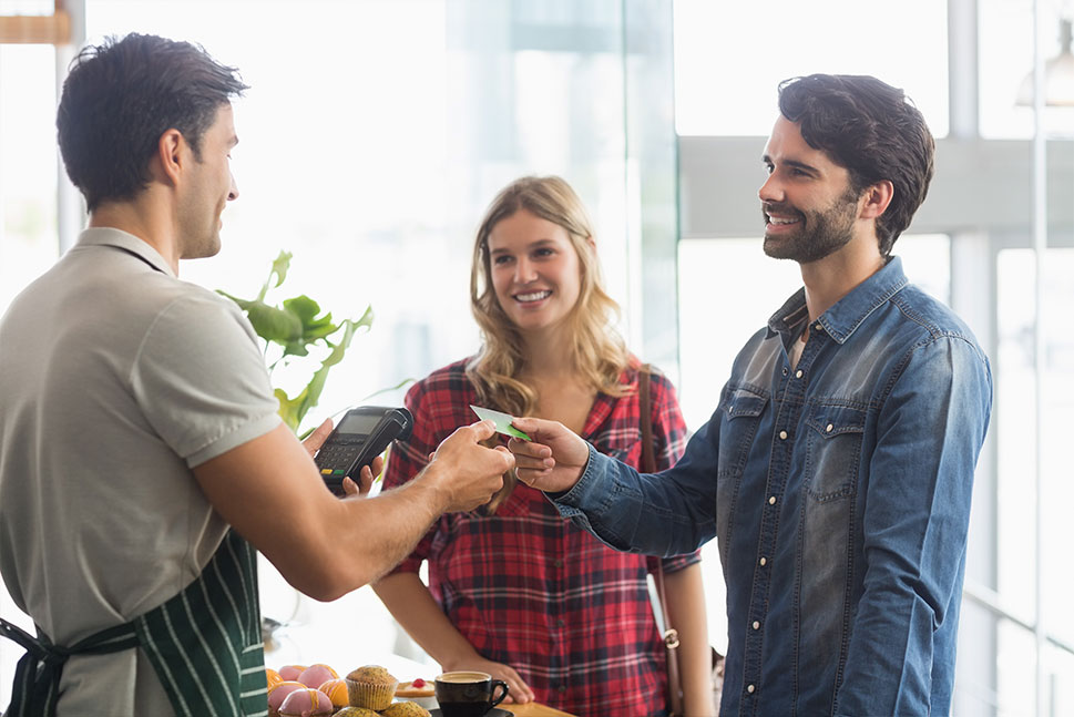 Photo of a Couple Using Debit Card